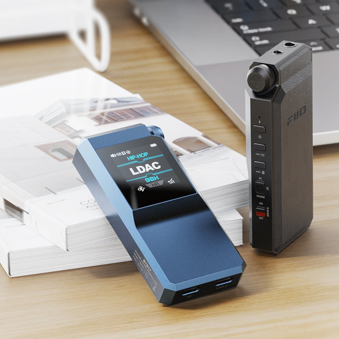 FiiO BTR17 in blue and black on a desk next to a laptop, screen showing LDAC