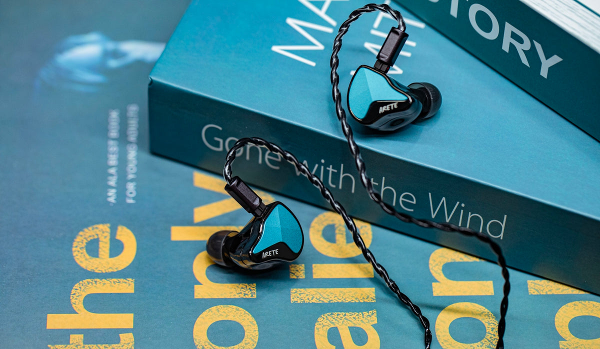 ZiiGaat x Fresh Reviews Arete II with black cable lying on a stack of books