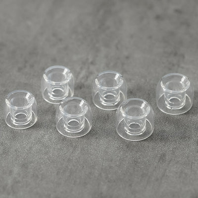 Divinus Prism Wide-Bore Ear Tips, clear silicone tips on a grey stone surface